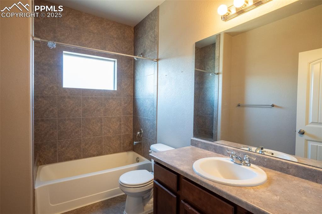 1985 Reed Grass Way Colorado Springs, CO 80915 - Photo 17 of 37 a bathroom with a granite countertop sink toilet mirror and bathtub