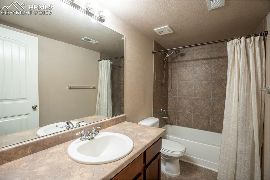 1985 Reed Grass Way Colorado Springs, CO 80915 - Photo 26 of 37 a bathroom with a sink a toilet a mirror and shower