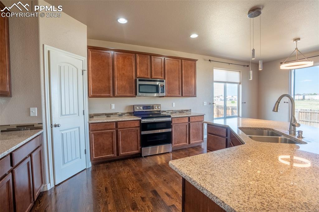 1985 Reed Grass Way Colorado Springs, CO 80915 - Photo 3 of 37 a kitchen with stainless steel appliances granite countertop a sink stove and refrigerator