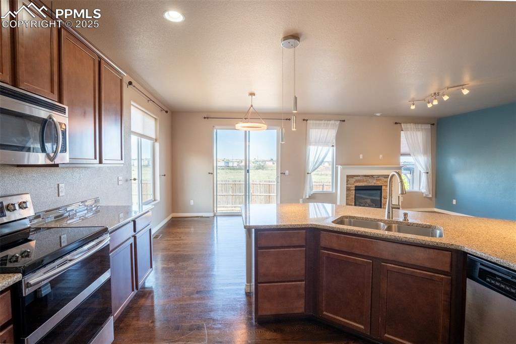 1985 Reed Grass Way Colorado Springs, CO 80915 - Photo 5 of 37 a kitchen with kitchen island granite countertop a sink cabinets and stainless steel appliances