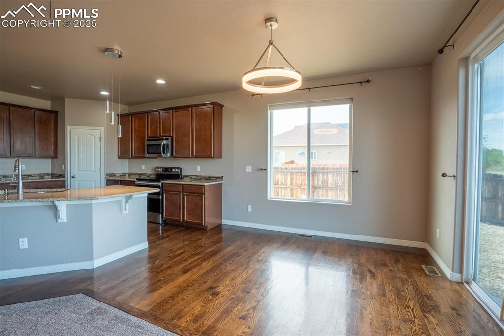 1985 Reed Grass Way Colorado Springs, CO 80915 - Photo 6 of 37 a kitchen with stainless steel appliances granite countertop a stove and a wooden floors