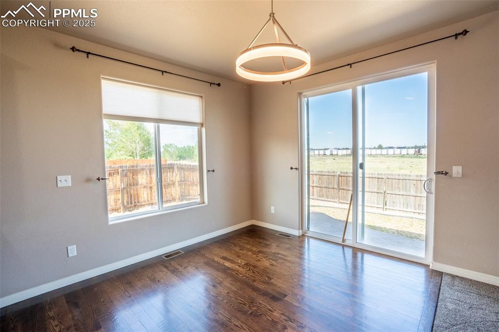 1985 Reed Grass Way Colorado Springs, CO 80915 - Photo 7 of 37 a view of an empty room with wooden floor and a window