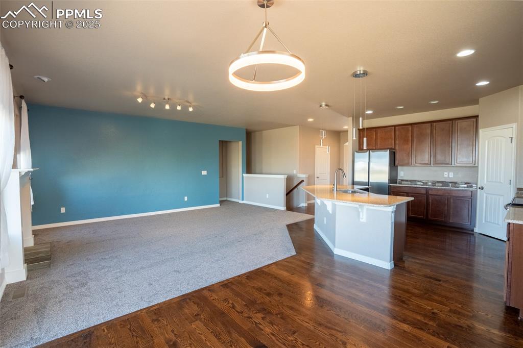 1985 Reed Grass Way Colorado Springs, CO 80915 - Photo 8 of 37 a open kitchen with kitchen island a sink dishwasher a refrigerator and a stove