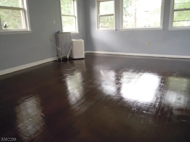 a view of a room with wooden floor and a window
