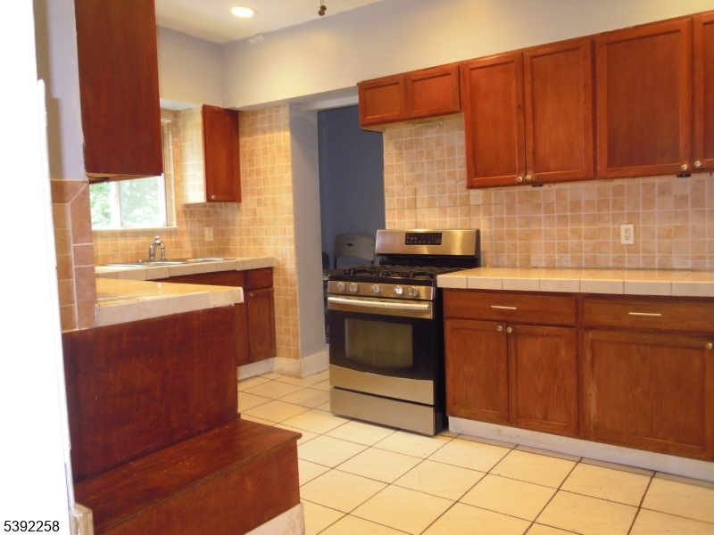56 Pine Grove Terrace, Unit UPR Newark, NJ 07106 - Photo 5 of 7 a kitchen with stainless steel appliances granite countertop a stove a sink and a refrigerator