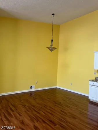 a view of a room with wooden floor and a ceiling fan