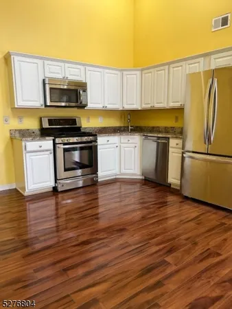 a kitchen with wooden floors and appliances