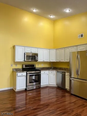 a kitchen with stainless steel appliances a stove a sink and a refrigerator
