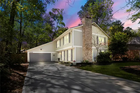 a front view of a house with a garden and trees