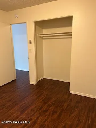 an empty room with wooden floor and closet