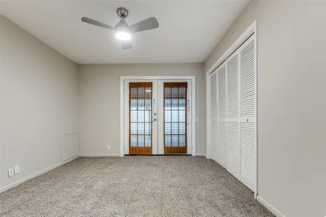an empty room with windows and entrance to other room