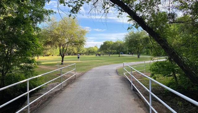 a view of a tennis ground with large trees