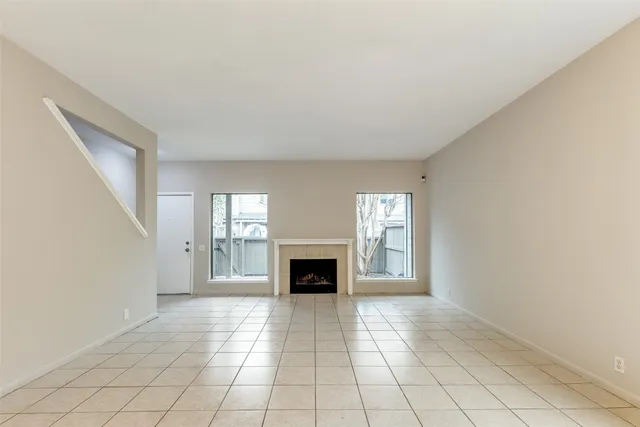 a view of an empty room with window and fire place