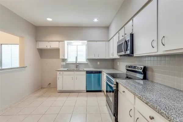 a kitchen with stainless steel appliances granite countertop a sink and a stove