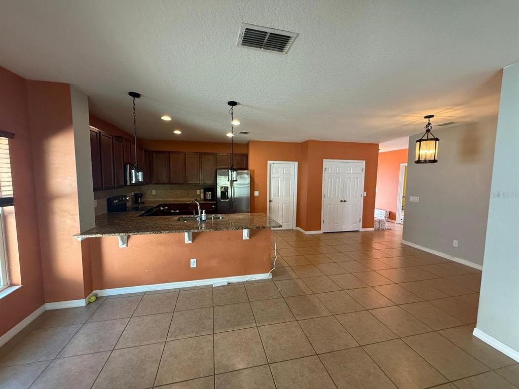 622 Samuel Place Davenport, FL 33837 - Photo 19 of 64 a view of a kitchen with a refrigerator and a stove top oven