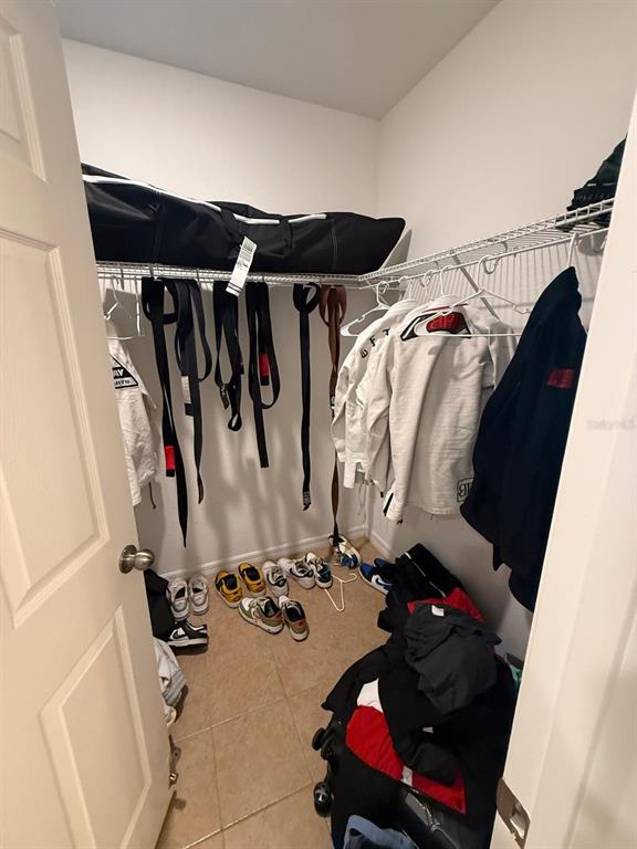 622 Samuel Place Davenport, FL 33837 - Photo 50 of 64 a view of walk in closet with clothes and shoes