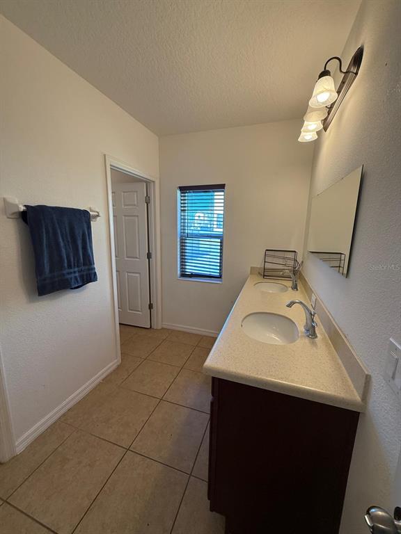 622 Samuel Place Davenport, FL 33837 - Photo 55 of 64 a bathroom with a sink and a mirror