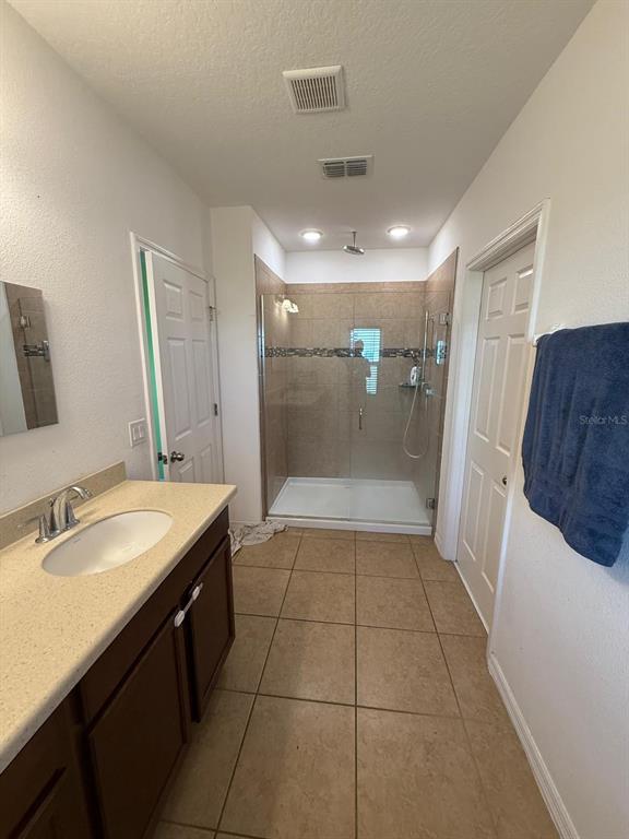622 Samuel Place Davenport, FL 33837 - Photo 56 of 64 a bathroom with a granite countertop sink a toilet a mirror and shower