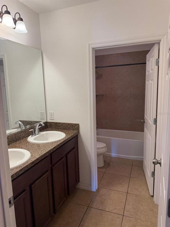 622 Samuel Place Davenport, FL 33837 - Photo 8 of 64 a bathroom with a granite countertop sink toilet and shower