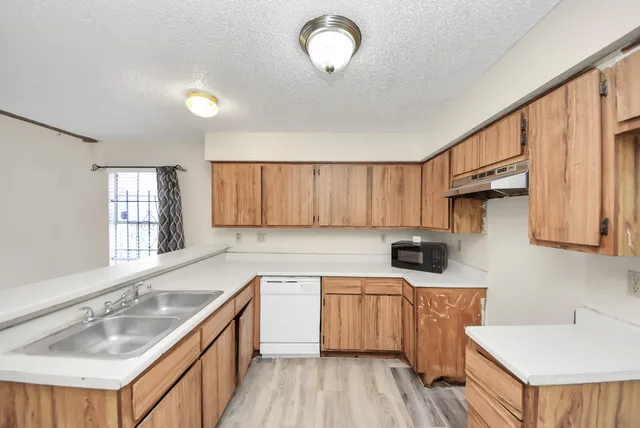 a kitchen with a sink a window and cabinets