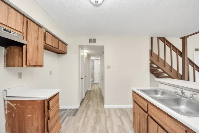 a kitchen with stainless steel appliances granite countertop a sink and a refrigerator