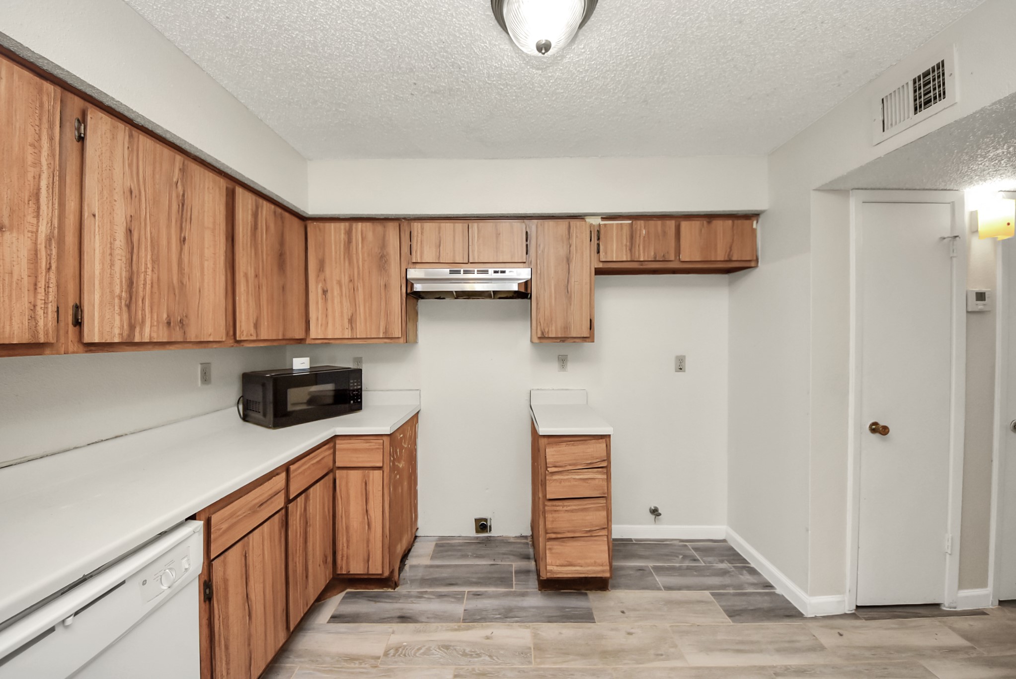 12232 Copper Tree Pvt Lane, Unit 122 Houston, TX 77035 - Photo 17 of 41 a kitchen with stainless steel appliances granite countertop a refrigerator a sink dishwasher and wooden cabinets with wooden floor