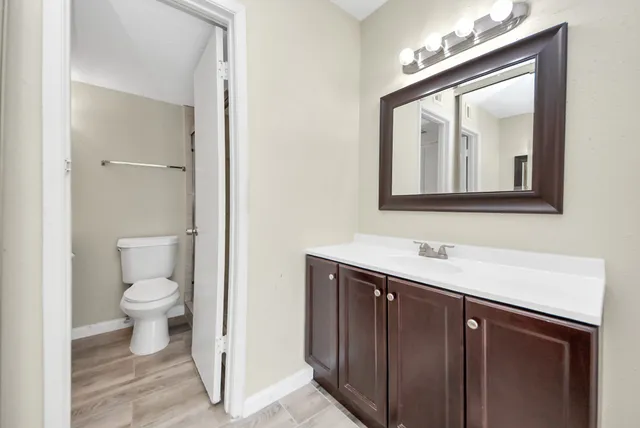a bathroom with a toilet sink and mirror