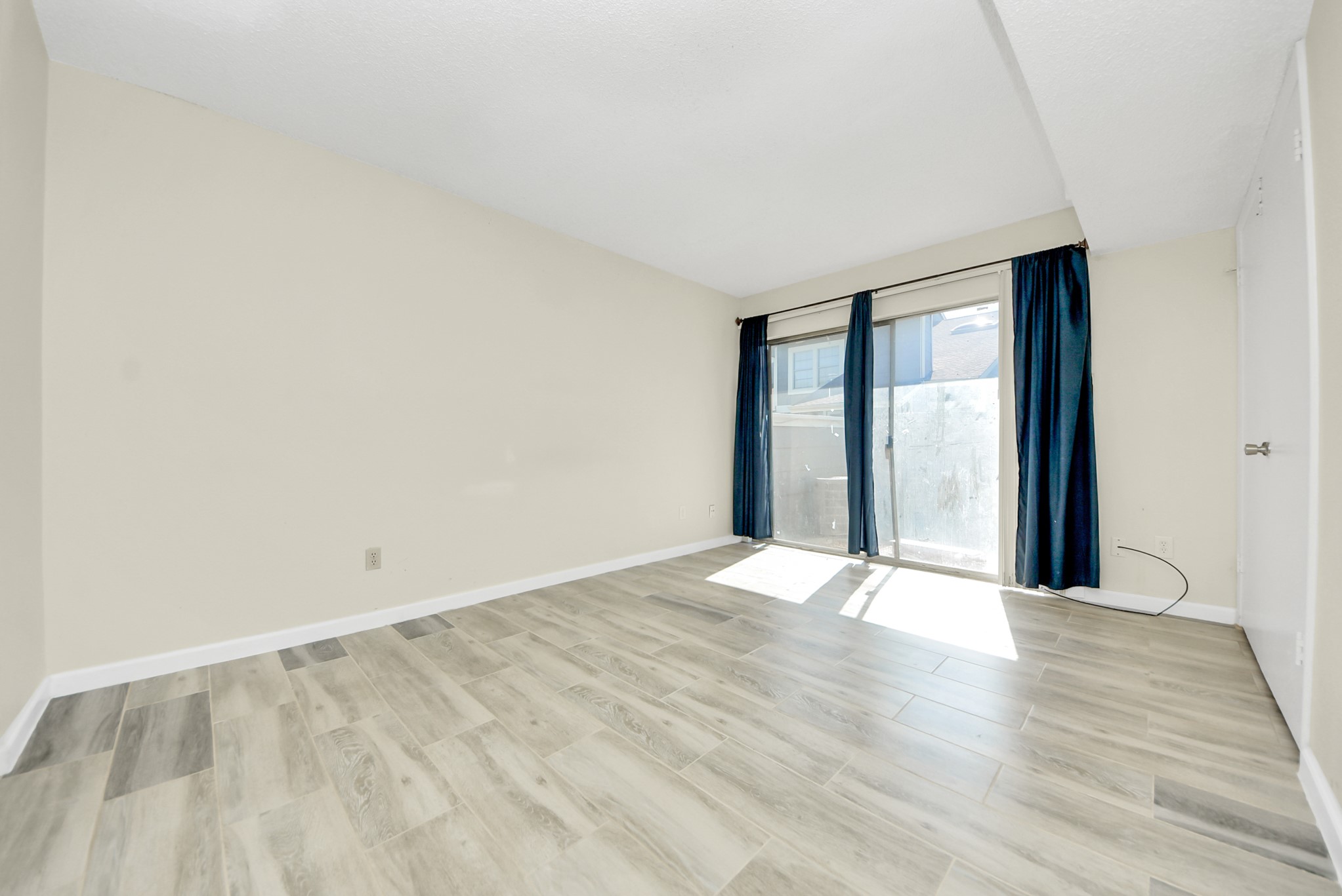 12232 Copper Tree Pvt Lane, Unit 122 Houston, TX 77035 - Photo 27 of 41 a view of an empty room with wooden floor and a window