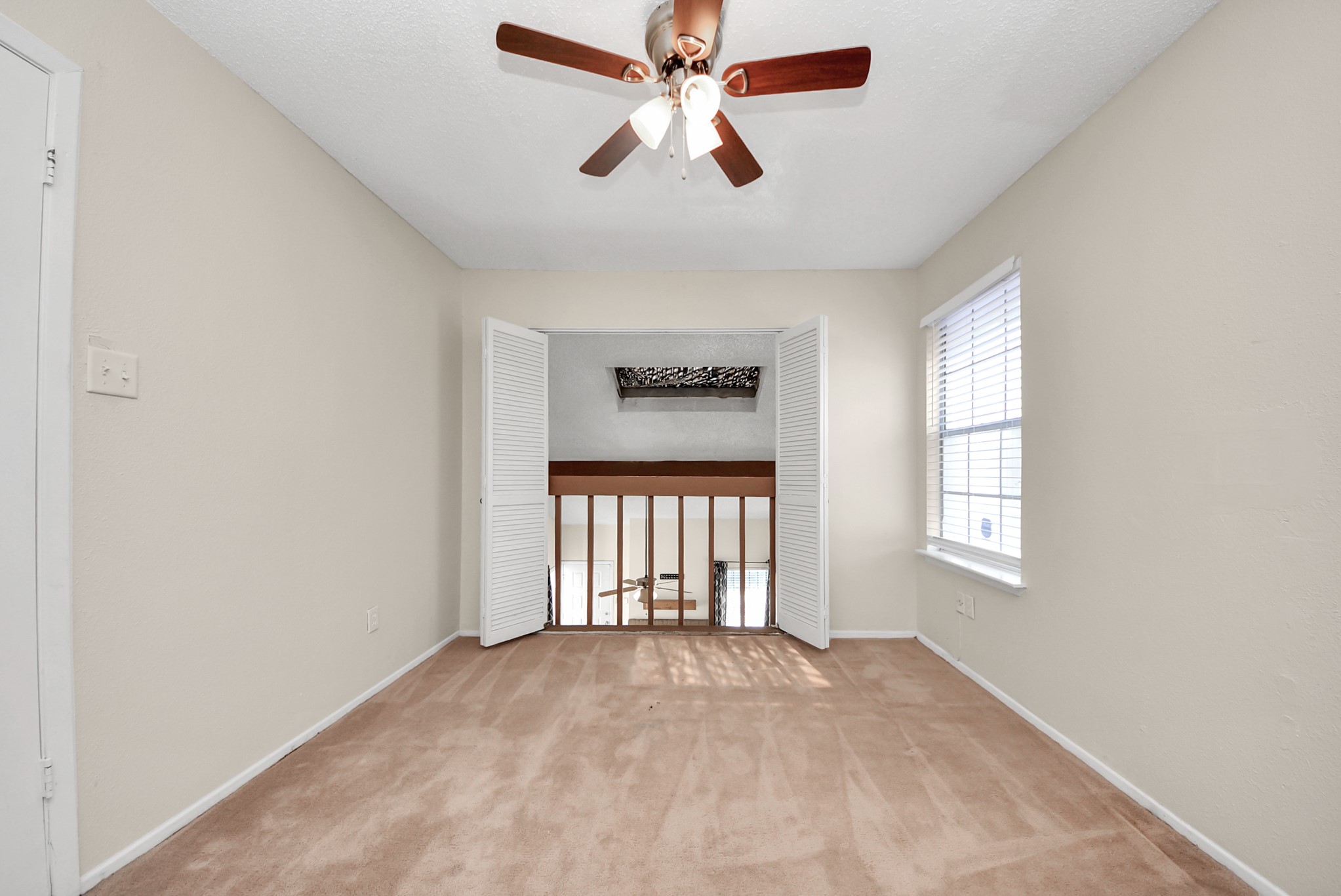 12232 Copper Tree Pvt Lane, Unit 122 Houston, TX 77035 - Photo 33 of 41 an empty room with windows and ceiling fan
