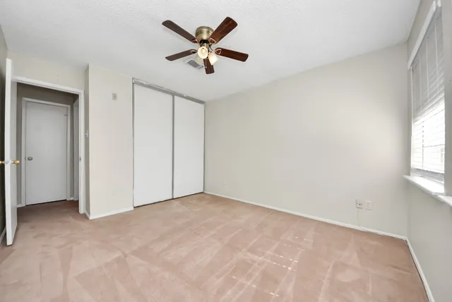 an empty room with windows and closet