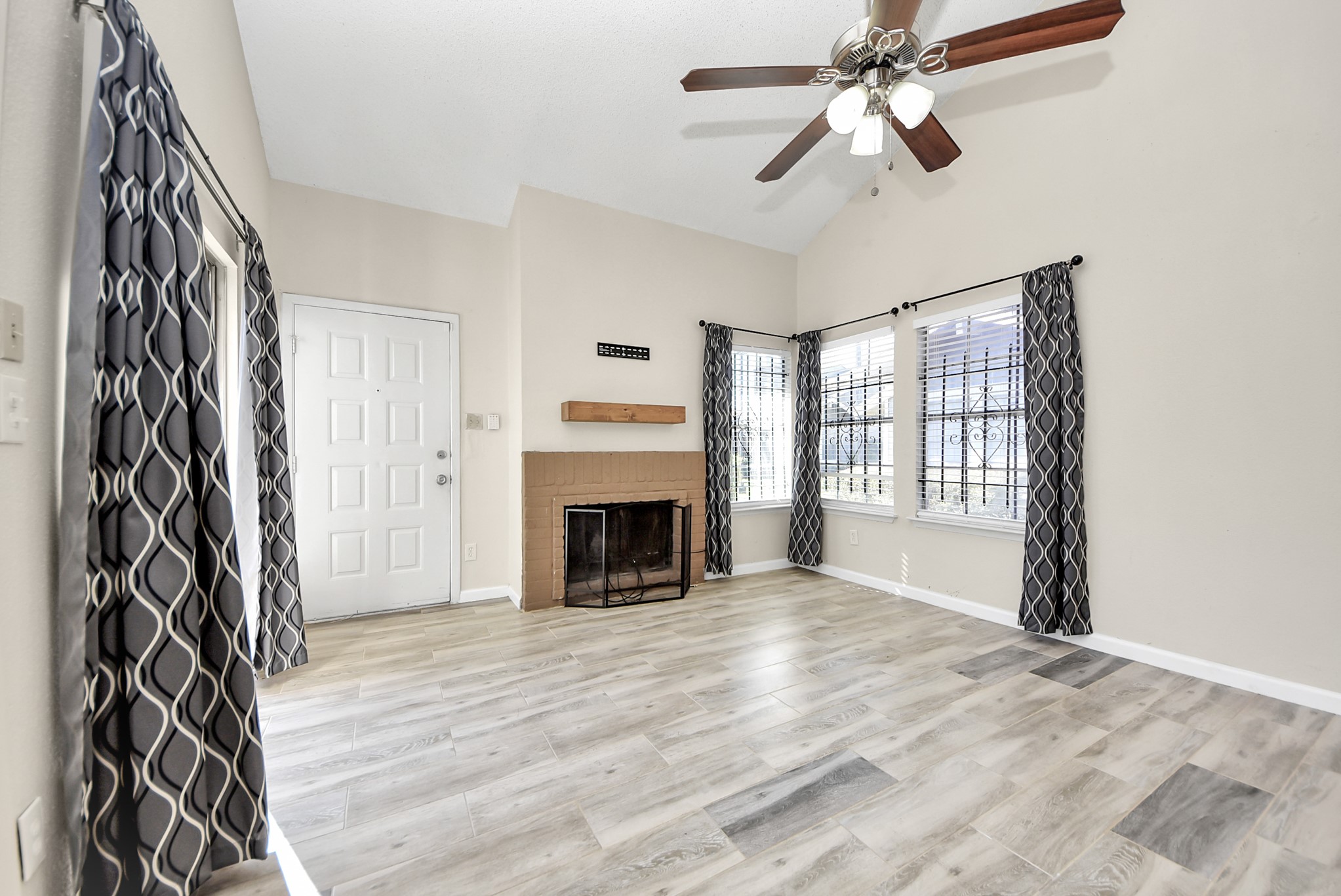 12232 Copper Tree Pvt Lane, Unit 122 Houston, TX 77035 - Photo 4 of 41 a view of an empty room with a fireplace and a window