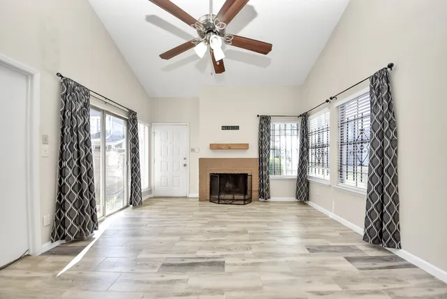 a view of an empty room with window and fire place