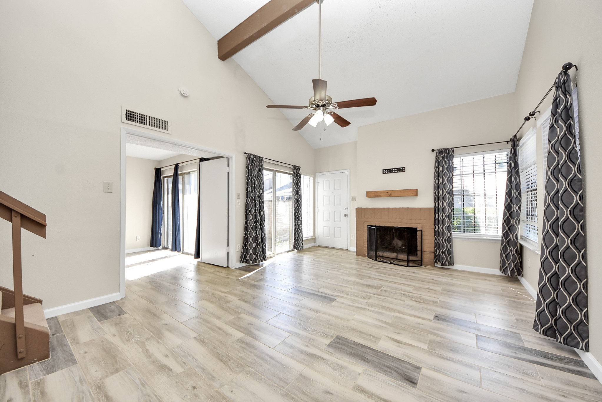 12232 Copper Tree Pvt Lane, Unit 122 Houston, TX 77035 - Photo 6 of 41 a view of a livingroom with a fireplace a ceiling fan and windows