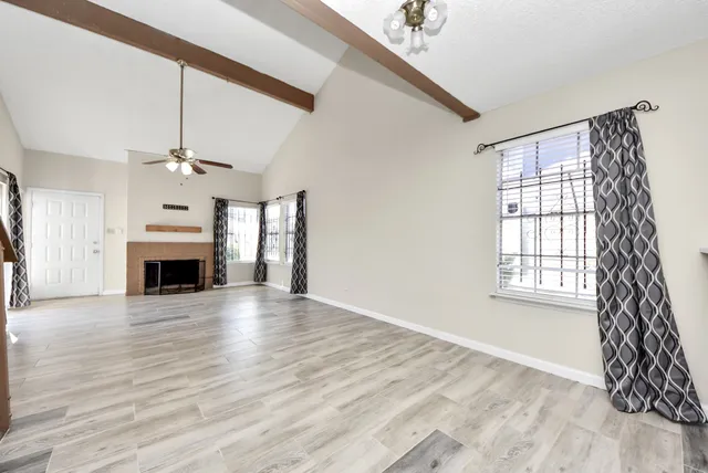 wooden floor fireplace and windows in an empty room