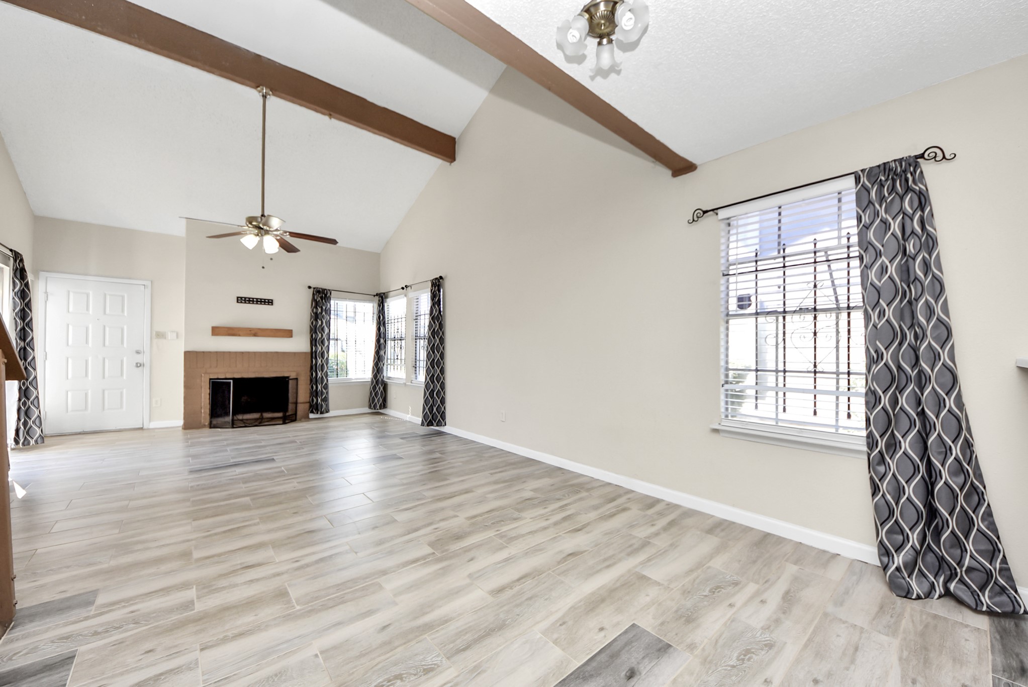 12232 Copper Tree Pvt Lane, Unit 122 Houston, TX 77035 - Photo 10 of 41 wooden floor fireplace and windows in an empty room