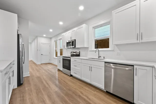 a kitchen with granite countertop cabinets stainless steel appliances a sink and a window