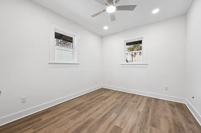 an empty room with a window and a fan