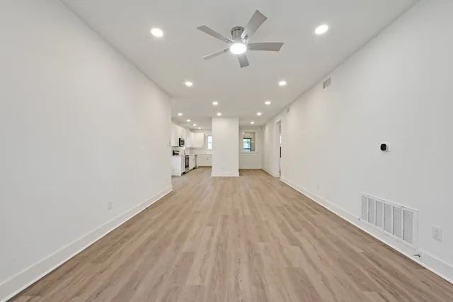 a view of empty room with wooden floor