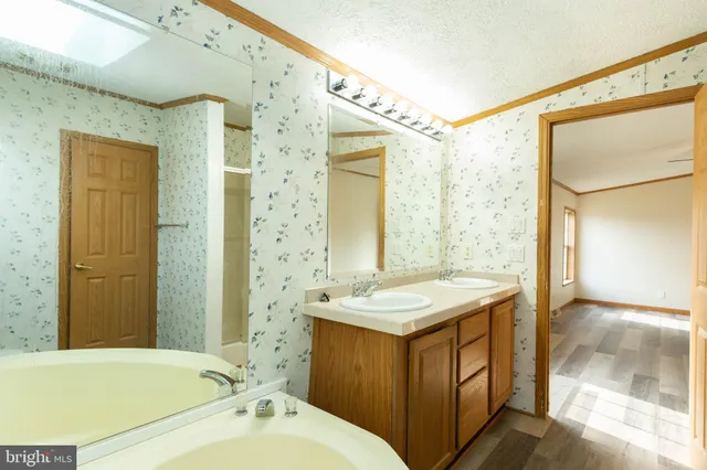 a bathroom with a tub sink and mirror