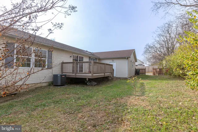 a view of backyard with wooden fence and large trees