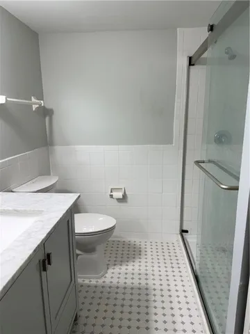 a bathroom with a granite countertop sink and a toilet