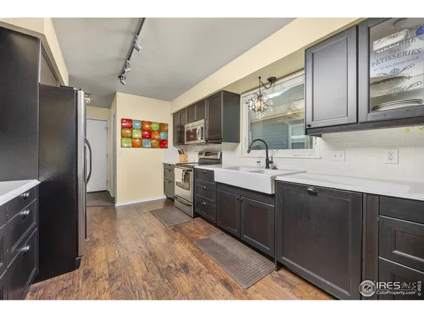 a kitchen with a sink refrigerator and cabinets