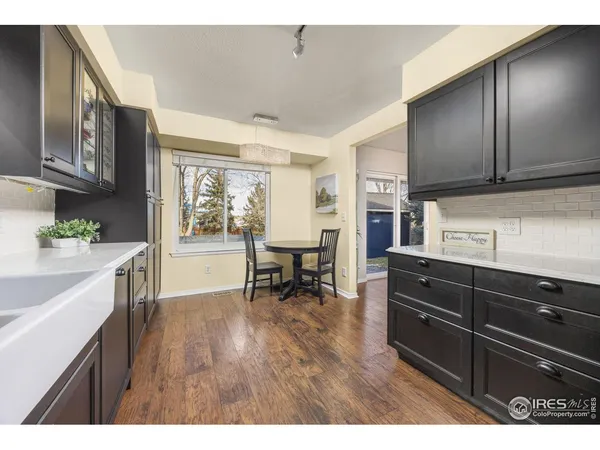 a kitchen with granite countertop wooden floors and wooden cabinets