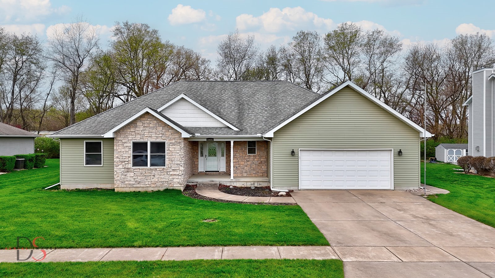 a view of a yard in front of a house with a large tree