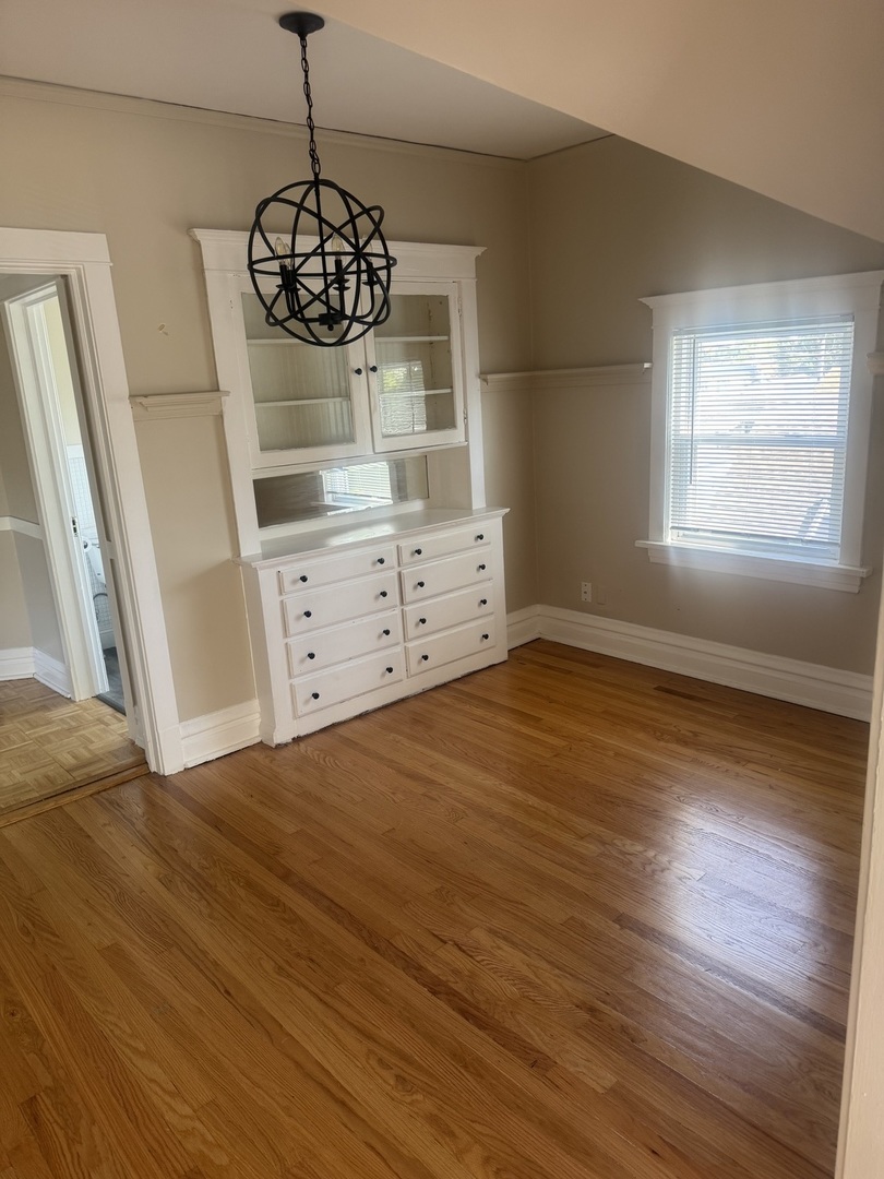 5632 West Berenice Avenue, Unit 3 Chicago, IL 60634 - Photo 5 of 6 a bedroom with a bed and wooden floor