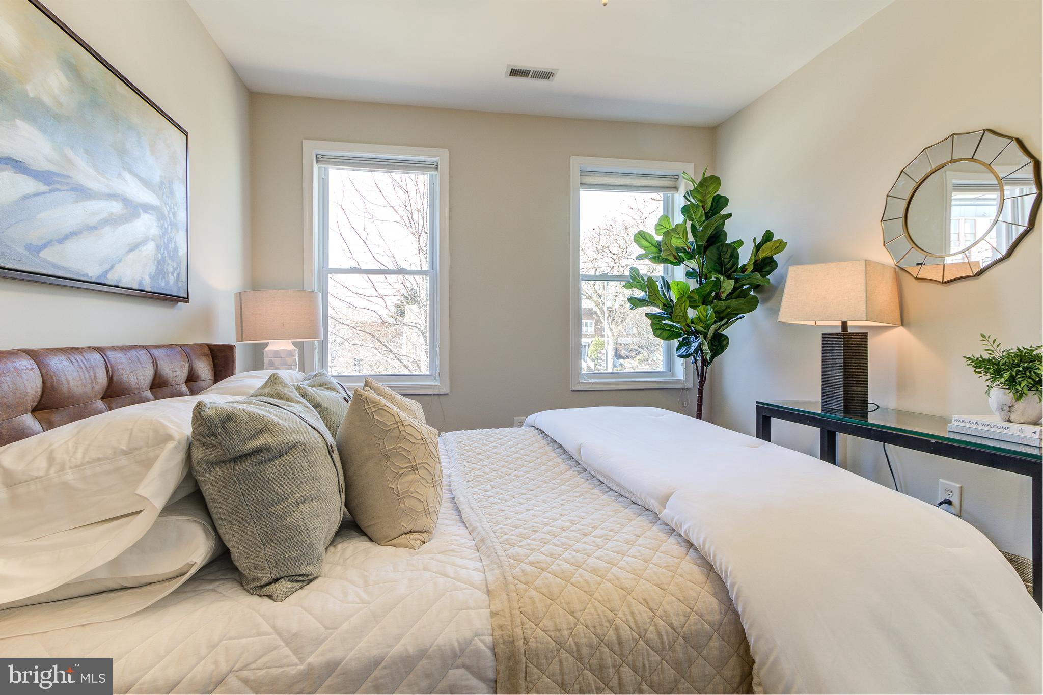 344 14th Street Southeast Washington, DC 20003 - Photo 22 of 31 a bedroom with a bed lamp and a large mirror on the dresser