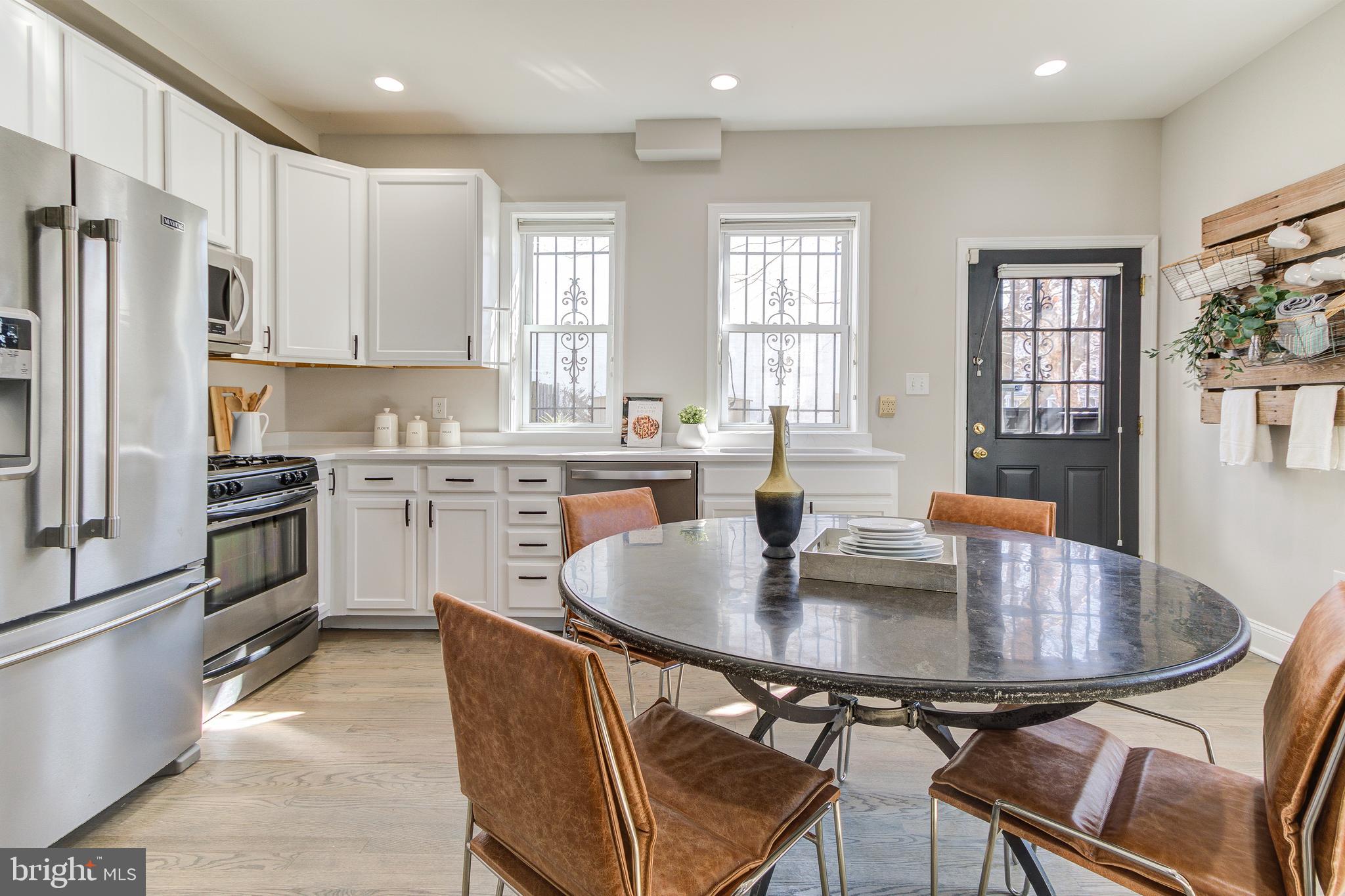 344 14th Street Southeast Washington, DC 20003 - Photo 9 of 31 a kitchen with stainless steel appliances granite countertop a dining table chairs refrigerator and microwave