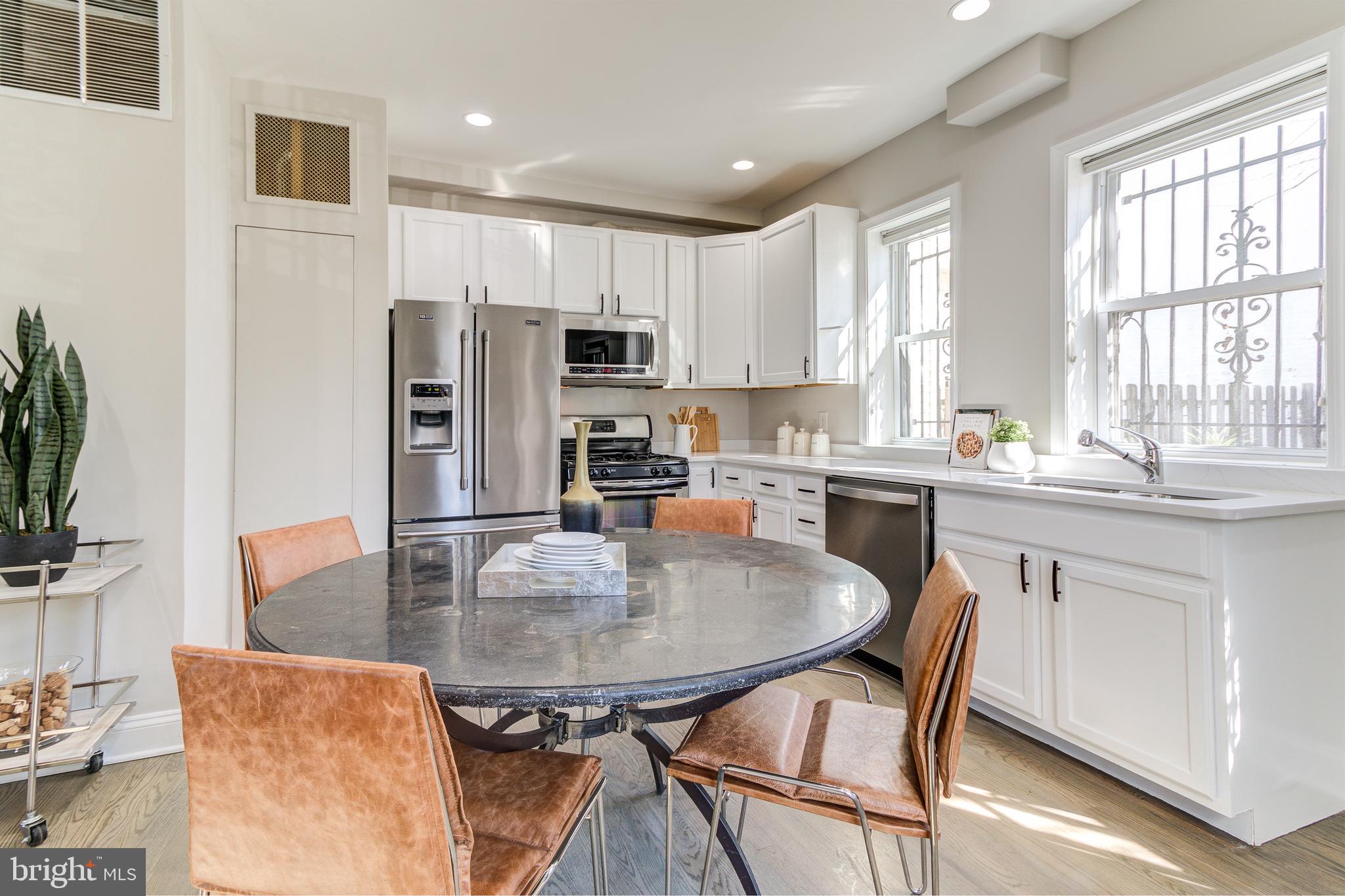 344 14th Street Southeast Washington, DC 20003 - Photo 10 of 31 a kitchen with stainless steel appliances granite countertop a stove a refrigerator a white table and chairs