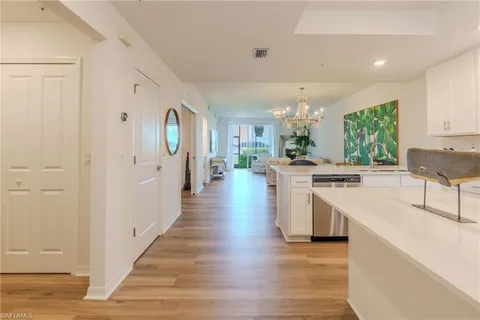 a large white kitchen with lots of counter space a sink and appliances