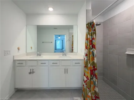 a bathroom with a sink mirror and a shower